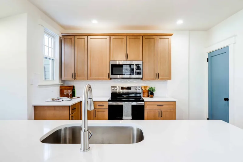 Natural wood kitchen seen across the sink and island