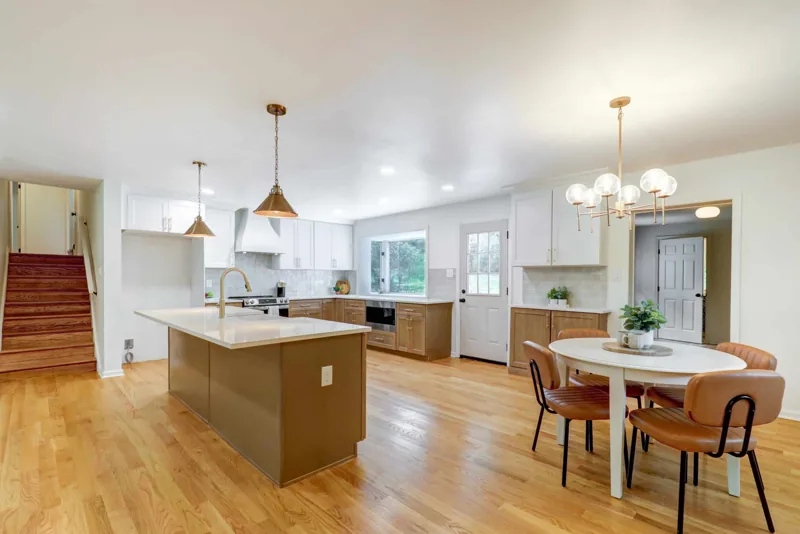 White and natural wood kitchen with an island and brass pendants