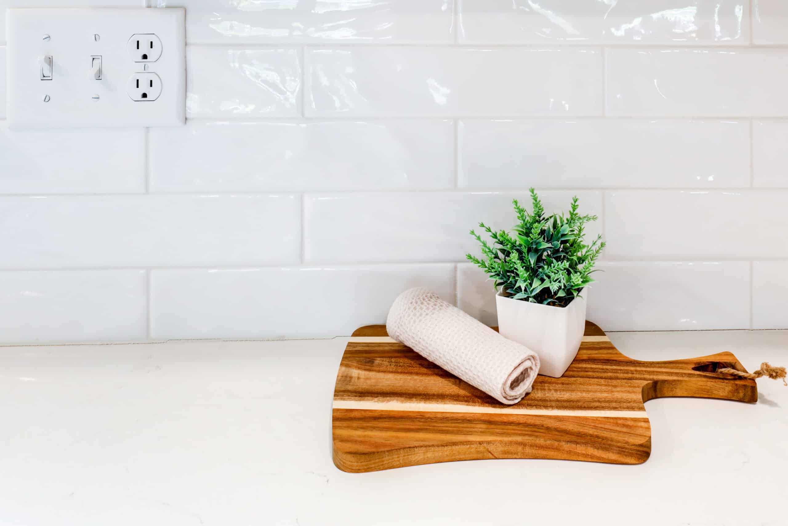 White subway tile backsplash above a light kitchen countertop