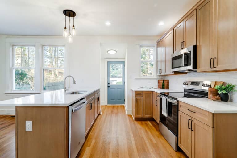 Kitchen work aisle between natural wood cabinets and an island