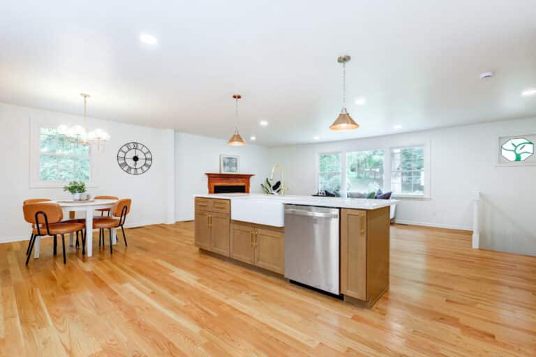 Open kitchen with a wood island, white upper cabinets and adjoining dining space