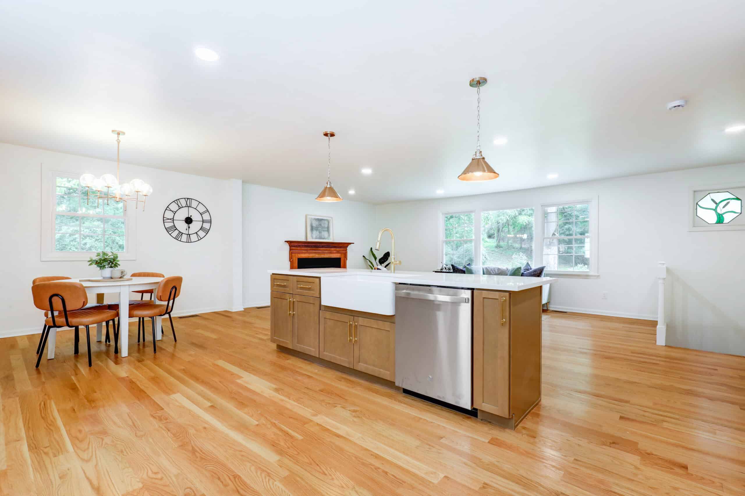 Open kitchen with a wood island, white upper cabinets and adjoining dining space