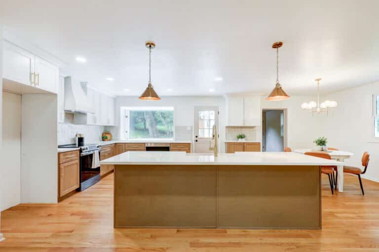 Kitchen island illuminated by two pendant lights and recessed ceiling lights