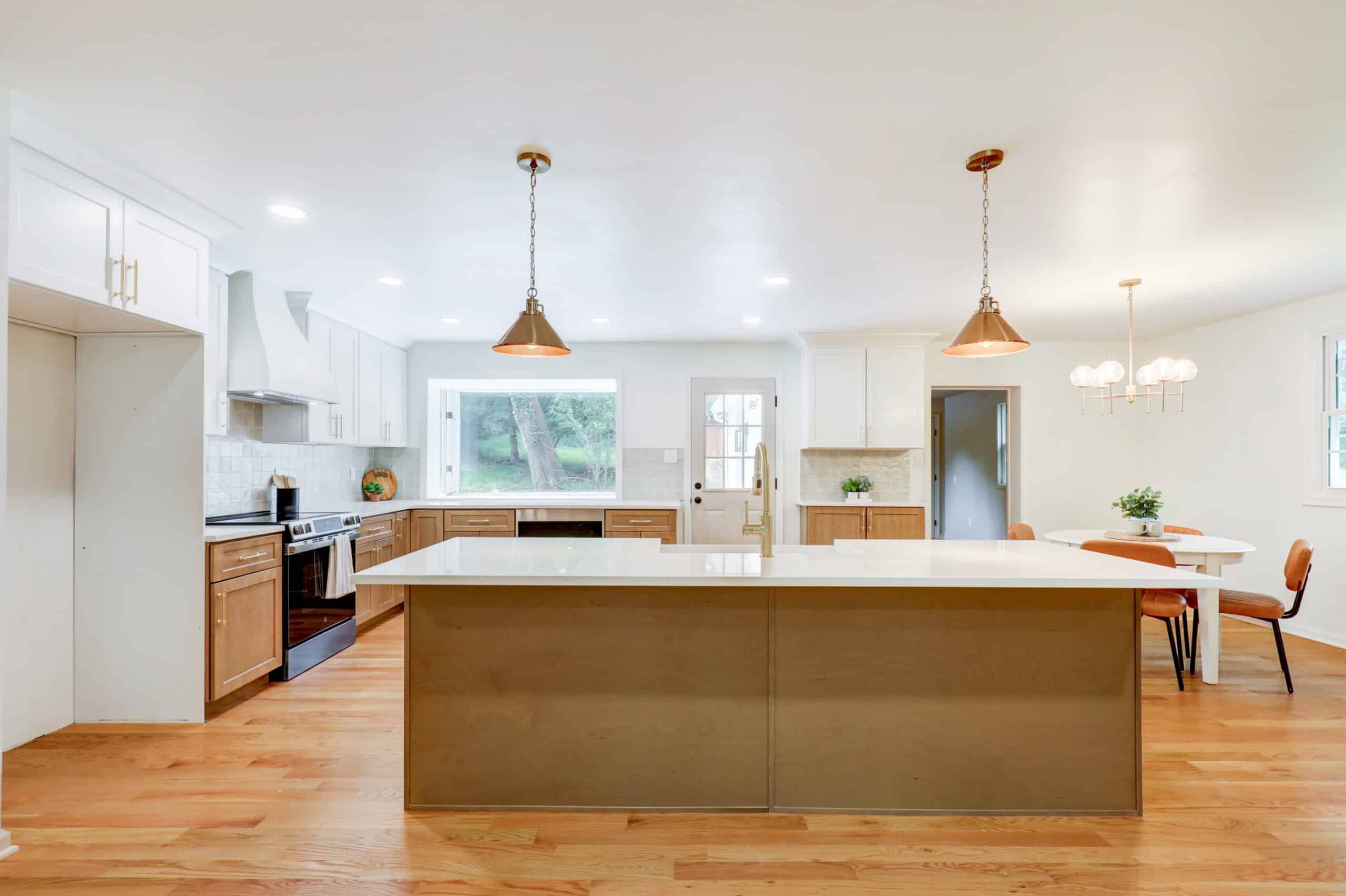 Kitchen island illuminated by two pendant lights and recessed ceiling lights
