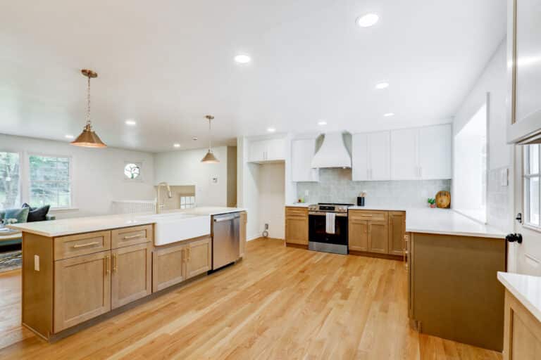 Kitchen combining white upper cabinets and natural wood base cabinets