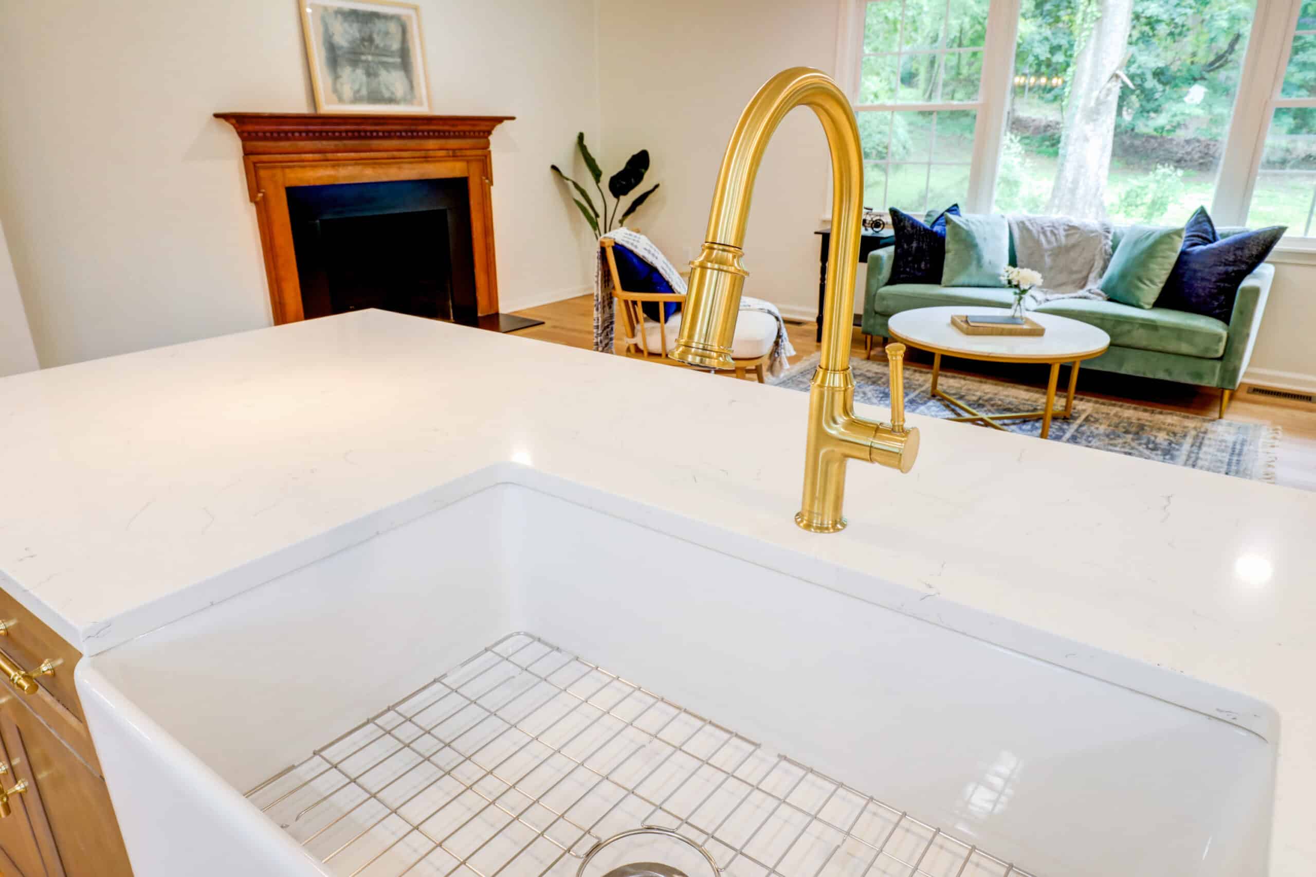White apron-front farmhouse sink with a gold-tone faucet