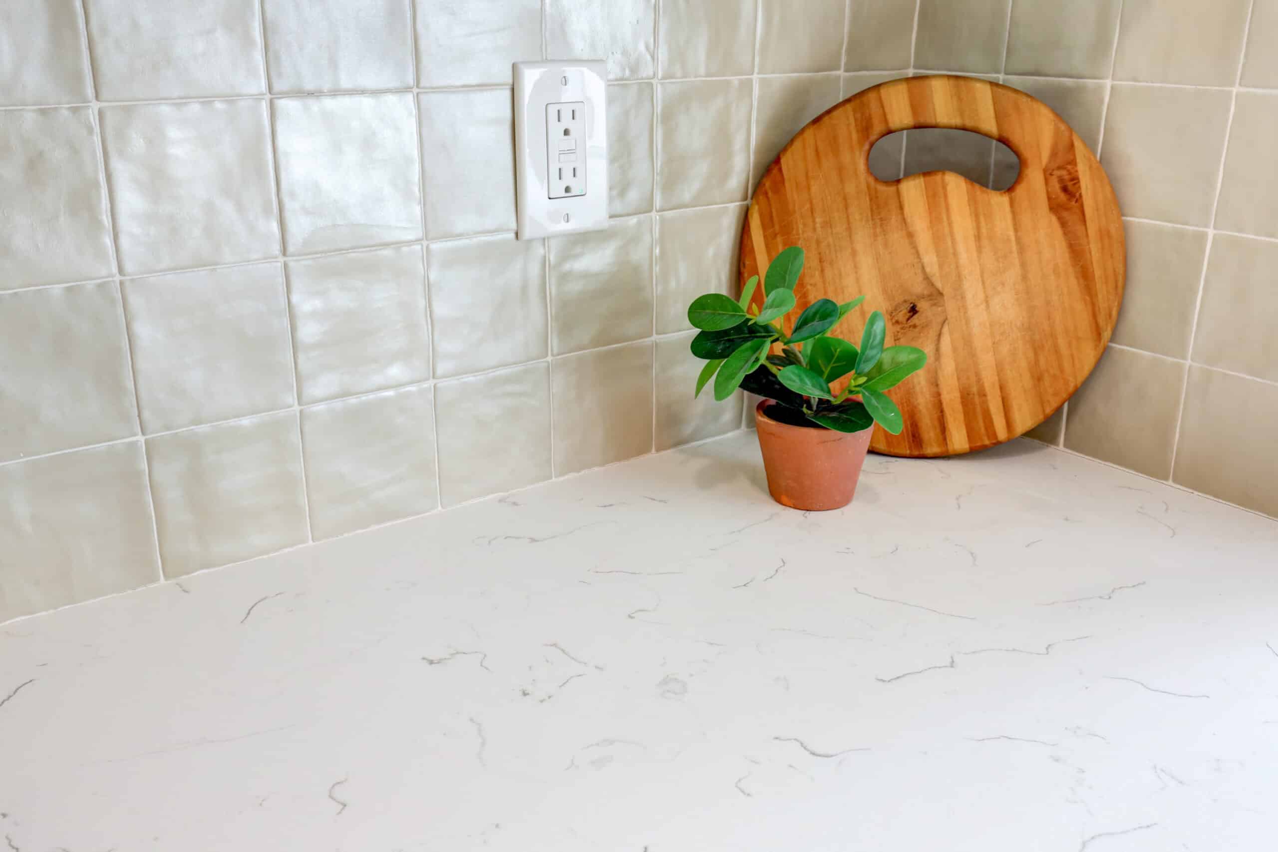 Light countertop with subtle veining beside a pale tile backsplash